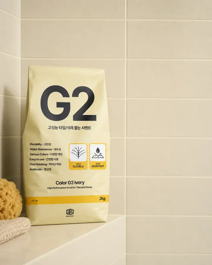 줄눈시멘트 G2 Color 03 Ivory 포장이 아이보리 타일 벽과 스펀지 옆에 놓인 이미지
